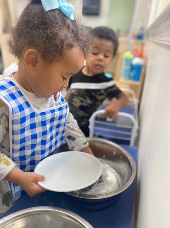 Preschooler doing the dishes.